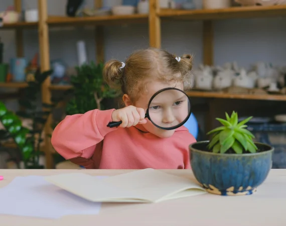 petite fille qui observe une plante à la loupe - association 1m2 ma santé